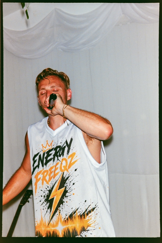 Steven performing on stage with a mic